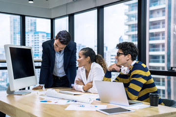 A group of young business people working together while sitting at their desks in the office, Business meeting.