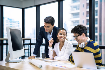 A group of young business people working together while sitting at their desks in the office, Business meeting.