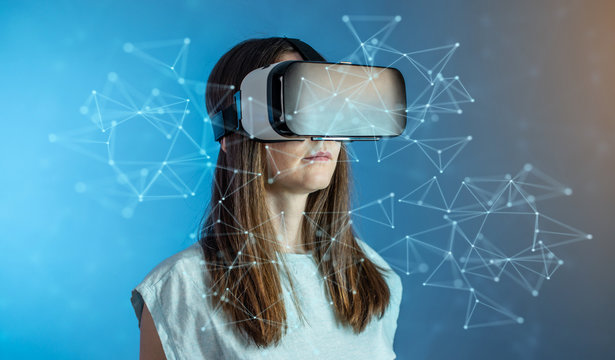 Woman wearing virtual reality glasses watching at 3D visualization in an abstract polygonal grid in a futuristic style.