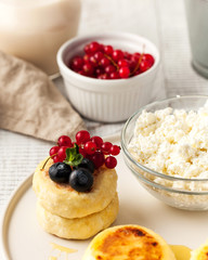 Cheesecakes with berries, cottage cheese and a bottle of milk. Food photo for menus, dairy stores and recipes.