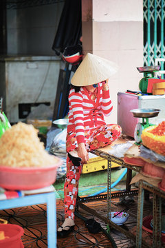 Woman in Vietnamese hat is talking mobile phone in Can Tho