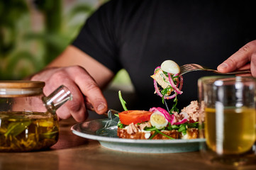 man eats caesar salad and drinks green tea