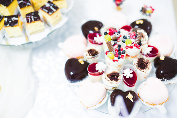 Delicious and tasty dessert table with cupcakes and shots at reception closeup