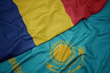 waving colorful flag of kazakhstan and national flag of romania.