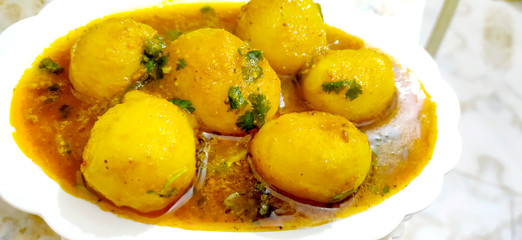 Indian Dum aloo curry using fried potatoes and spices, served in a bowl. selective focus