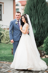 Naklejka premium Romantic wedding moment, couple of newlyweds smiling portrait, bride and groom hugging