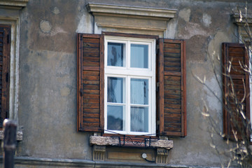 Obraz premium Italian window on the old wall facade with open wooden shabby brown paint shutters