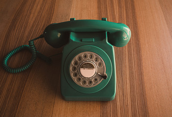 Teléfono vintage de color verde sobre mesa de madera