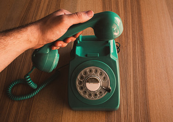 Teléfono vintage de color verde sobre mesa de madera
