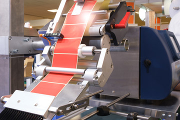 Fragment of the conveyor of sticking labeling machine. Abstract industrial background.