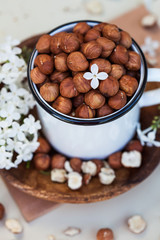  A handful of peeled hazelnuts on a wooden plate. Food photo of a healthy snack, veggie snacks.