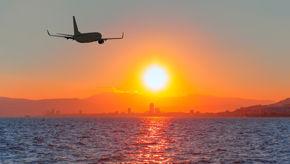 Airplane flying above city at sunset - Izmir, Turkey