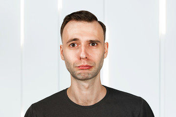 Unhappy, sad young man on white background