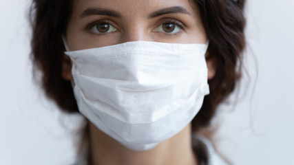 Close up portrait of young woman wear medical mask protecting from coronavirus pandemic, serious millennial female in protective face cover against spread of covid-19 virus, corona, epidemic concept