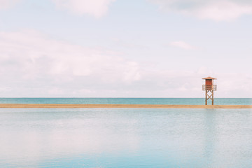 Relaxing deserted beach with lifeguard tower. The water flooded the sandy area.Enjoy the life Copy space.Travel, tourism, holiday concept.