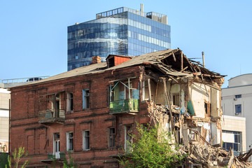House demolished against the backdrop of a modern glass building
