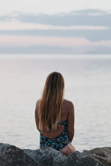 Fototapeta na wymiar Young woman enjoying sunset on the beach
