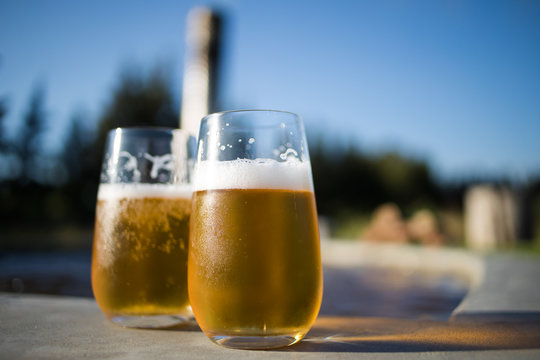 Close up image of two cold beers on a warm summer day next to the pool