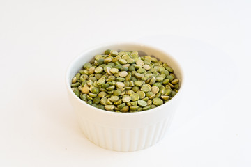 Split peas in a small white bowl isolated on a white background