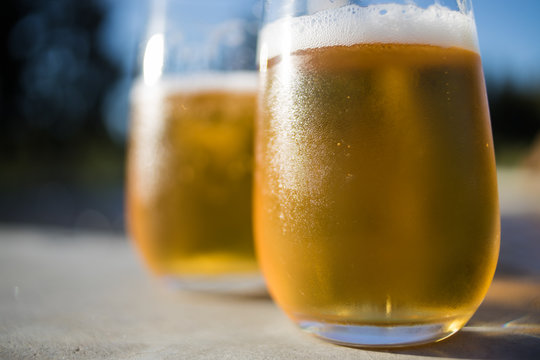Close up image of two cold beers on a warm summer day next to the pool
