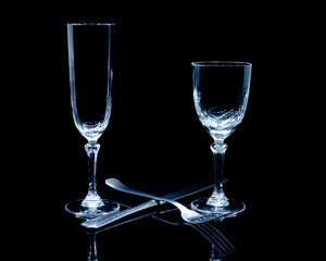 Verres à pied sur fond noir avec reflet.