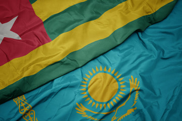 waving colorful flag of kazakhstan and national flag of togo.