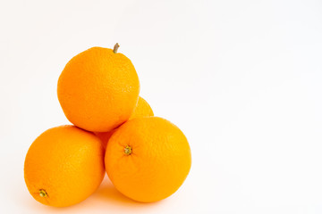Closeup of four oranges stacked isolated on a white background