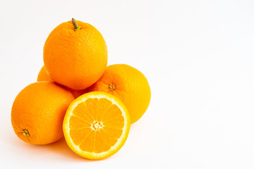Four oranges stacked and an orange slice isolated on a white background