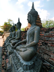 Stone Buddha statues and blue sky background at Wat Yai Chaya Mongol in Ayutthaya, Thailand