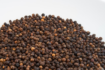 Close-up of black peppercorns on a white background