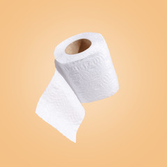 white toilet paper on a beige background. The concept of sanitary standards