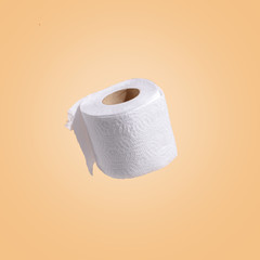 white toilet paper on a beige background. The concept of sanitary standards