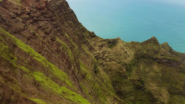 Stunning aerial view of Na Pali Coast State park. Unique Hawaii nature in its exotic beauty. Calm blue ocean and coastline view from over the pictorial volcanic coastal cliffs. 4K
