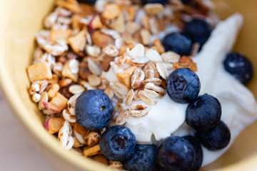 macro shot of a breakfast cup with cereals, yogurt and berries