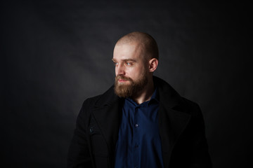 a mysterious portrait of a man with a beard on a black background with a small amount of light