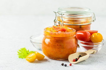 Spicy fermented cherry tomatoes in glass jar. Selective focus, copy space.