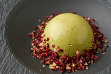 Matcha green tea, mint, lemon raw mousse cake on black plate. Contemporary minimalistic style. Raw Healthy Paleo green Avocado Cake..