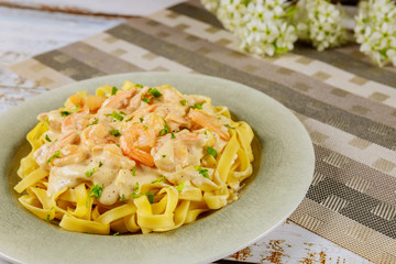 Alfredo fettuccine pasta with shrimps on plate.