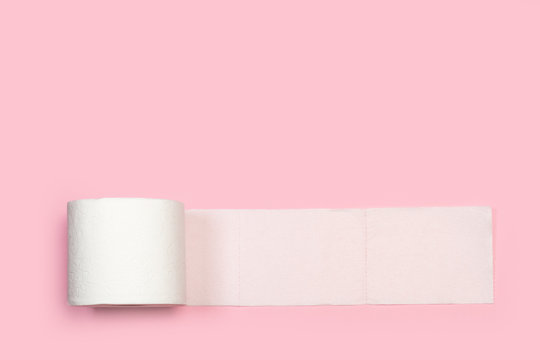Un rollo de papel higiénico desenrollado sobre fondo liso rosa aislado. Vista superior. Copy space