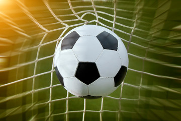 Fototapeta na wymiar soccer ball in a net and a blue sky