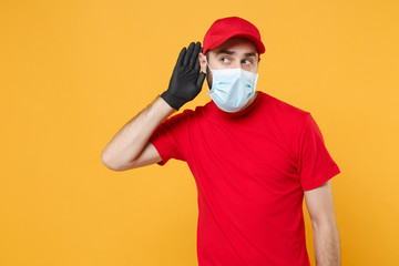 Delivery man in red cap blank t-shirt uniform sterile face mask gloves isolated on yellow...