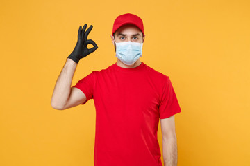 Fototapeta na wymiar Delivery man in red cap blank t-shirt uniform sterile face mask gloves isolated on yellow background studio Guy employee working courier Service quarantine pandemic coronavirus virus 2019-ncov concept