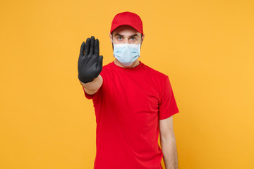 Delivery man in red cap blank t-shirt uniform sterile face mask gloves isolated on yellow...