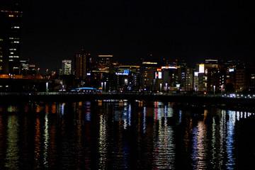 city buildings reflecting on the water at night