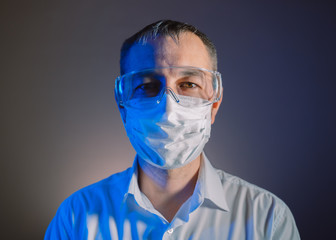 Portrait of a man in medical mask and protective glasses.