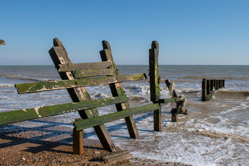 Old wooden sea defence damaged by winter storms on Climping Beach England.