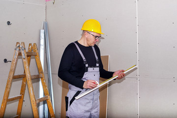 Construction site, worker installing gypsum board