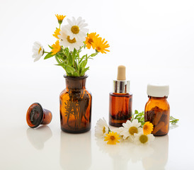 Obraz na płótnie Canvas Wild flowers and medical brown glass containers isolated on white background