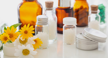 Obraz na płótnie Canvas Wild flowers and herbal medicine products on white background