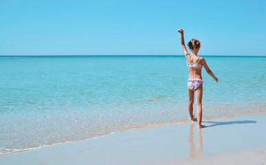 Happy little girl has a fun on the beach.